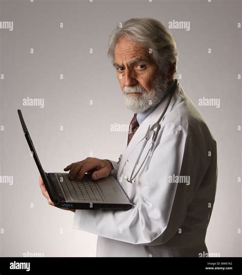 Mature Doctor With Laptop Wearing Stethoscope And White Lab Coat November 9 2010 © Katharine
