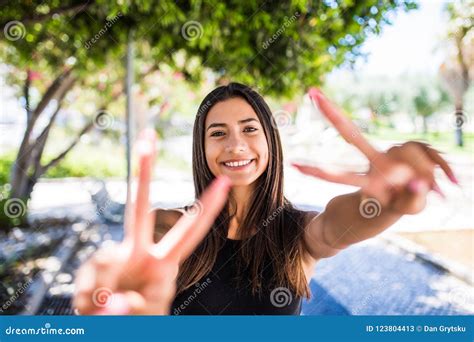 Portrait Of A Cheerful Woman Lovely Woman Showing Victory Or Peace Sign In The Summer Street