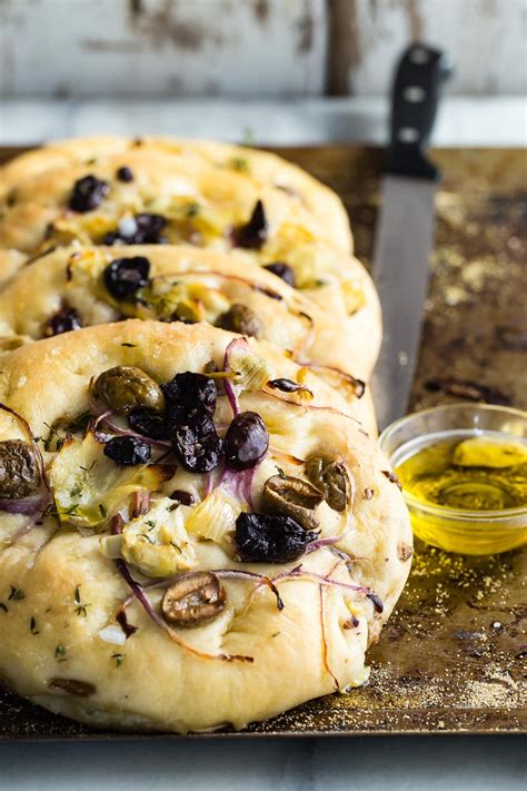 It's a flatbread made with a generous amount of olive oil, and has a long history. Focaccia Bread with Olives and Artichokes - Foodness Gracious