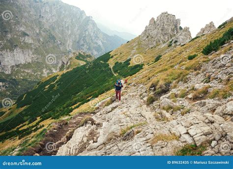 Hikers Walking Along A Trail In Rugged Mountain Terrain Stock Image