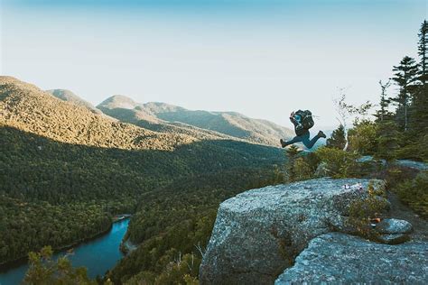 Hd Wallpaper Man Jumping On Gray Rocky Mountain During Daytime Nature