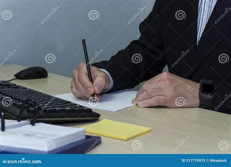 Closeup Shot Of Male Writing On Paper With A Computer Keyboard And