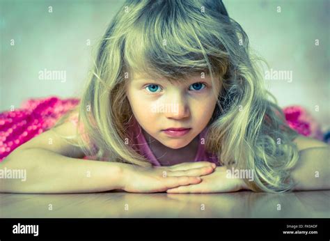 Beautiful Blond Child Girl With Long Hair And Blue Eyes Lying On Floor
