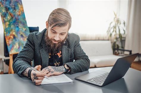 Joyful Freelancer Hipster Wearing Suit Does His Paperwork At Table