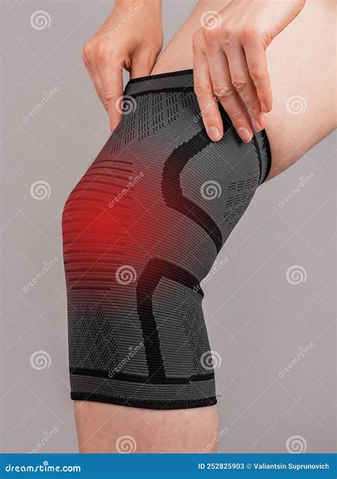 Woman Wearing Knee Brace To Reduce Pain Female Leg With Red Spot Stock