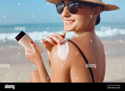 Girl Using Sunscreen To Skin Beautiful Woman In Bikini Applying Sun Cream On Tanned Shoulder