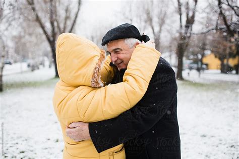 Old Couple Hugging Outdoors In Snowfall By Stocksy Contributor Jovana Rikalo Stocksy