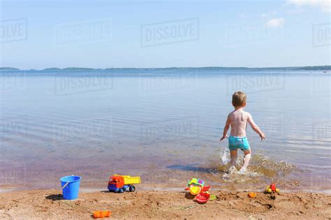 Boy Playing In Water Stock Photo Dissolve