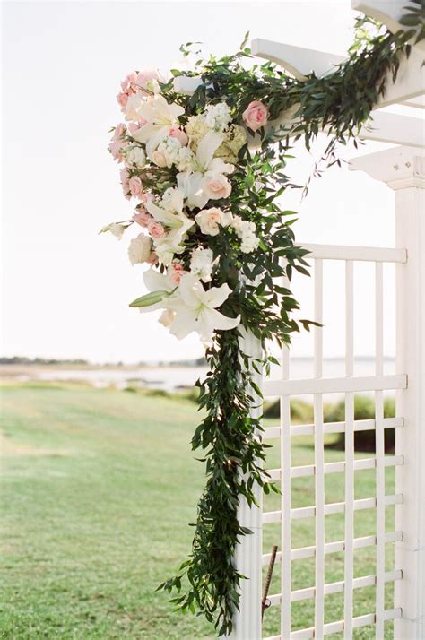 Small clusters of bright flowers were carefully placed around this round arch for a breathtaking ceremony structure. Hand-Woven Italian Ruscus Wedding Arbor Decor