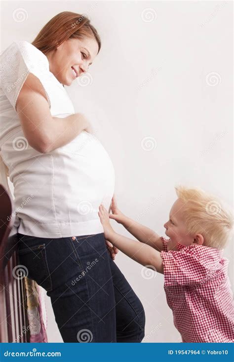 Mujer Embarazada Que Juega Con Su Hijo Joven Foto De Archivo Imagen