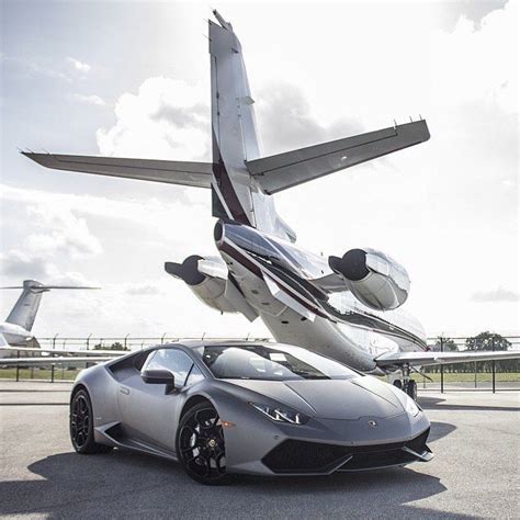 A Silver Sports Car Parked In Front Of An Airplane
