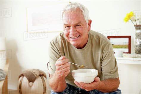 Senior Man Eating Cereal From Bowl Stock Photo Dissolve