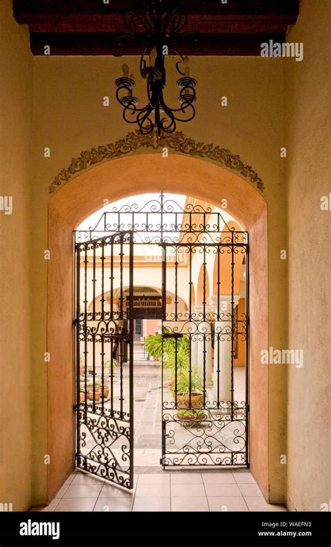 View Through Open Wrought Iron Gate To Beautiful Courtyard Garden