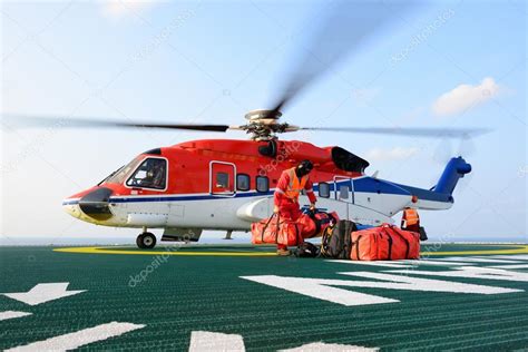 Coast guard or the occupational safety & health. o oficial de pouso helicóptero carregando bagagem de ...