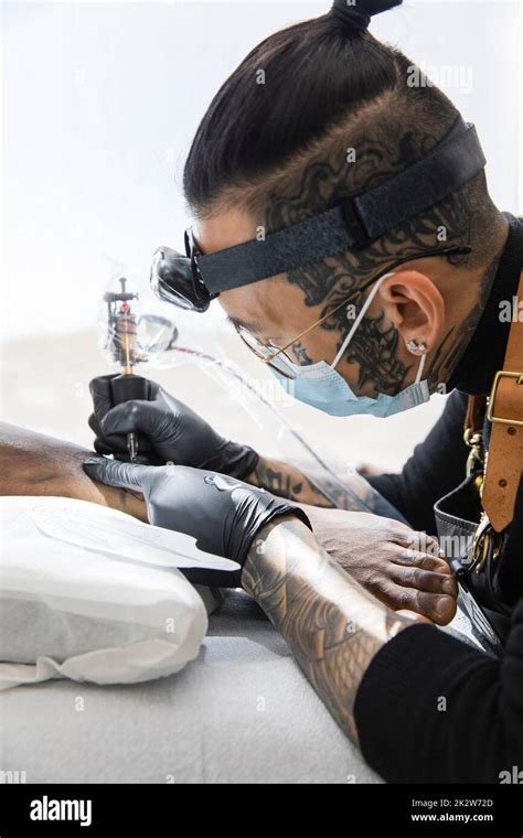 Tattoo Artist At Work On Customers Leg Stock Photo Alamy