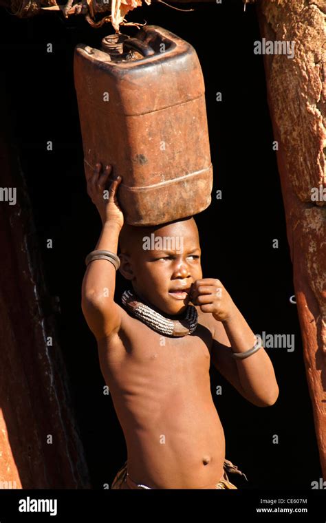 Young Himba Girl Carrying Water In Village Near Opuwo Namibia Stock