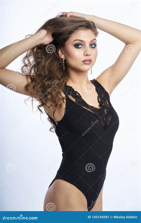 menina bonita no roupa de banho que levanta contra o fundo branco cinzento imagem de stock