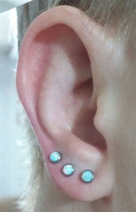 An Ear With Three Small Blue Stones On It