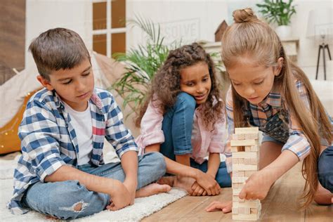 Multicultural group of children playing blocks wood game together at ...