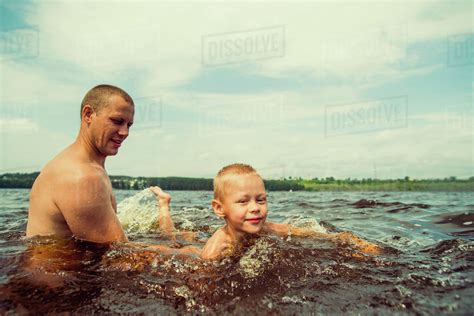 Caucasian Father And Son Swimming In Lake Stock Photo Dissolve