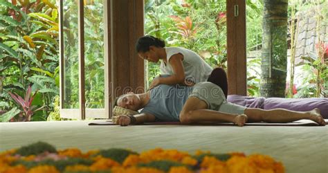 Young Beautiful And Exotic Asian Indonesian Therapist Woman Giving Traditional Thai Massage To