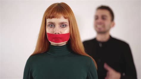 Portrait Of Young Woman With Taped Mouth Is Silent While Aggressive
