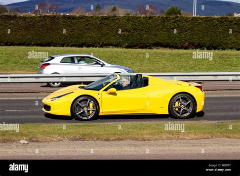A Yellow Ferrari 458 Italia Spider Convertible Sports Car Travelling