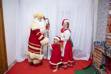 Vó tirando fotografia com sua neta e Papai Noel celebrando natal ceia download Designi