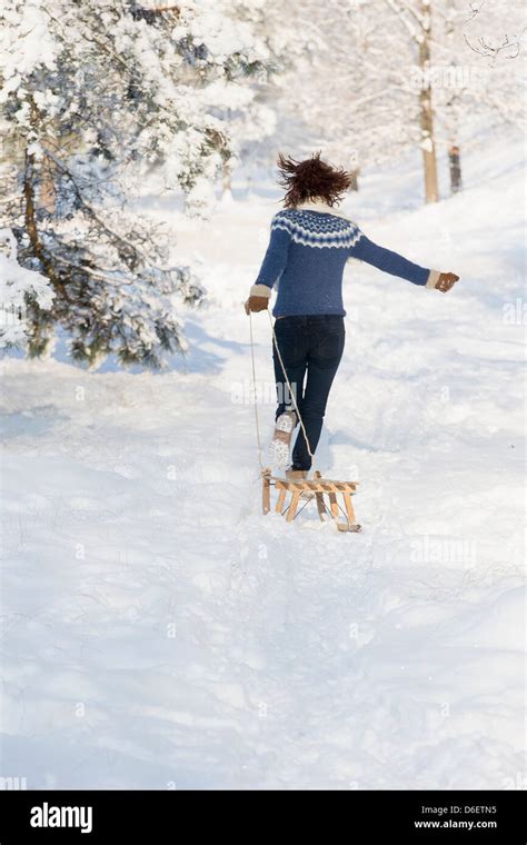 Caucasian Woman Pulling Sled In Snow Stock Photo Alamy