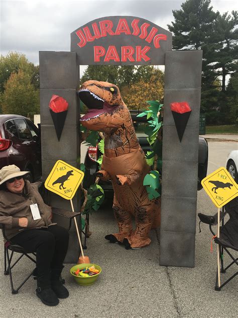 Some People Are Sitting In Lawn Chairs And One Is Dressed As A Dinosaur