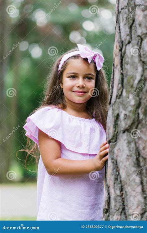 Portrait Of Cute Little Child Girl Hugging Tree In The Park Summer