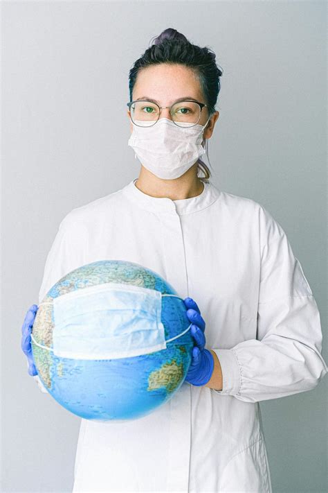 Person With A Face Mask And Latex Gloves Holding A Globe · Free Stock Photo