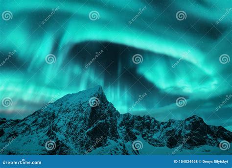 Aurora Borealis Above The Snow Covered Mountain Peak Stock Photo