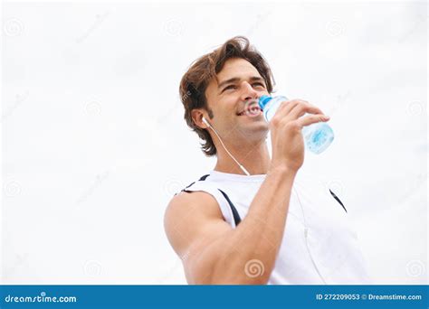 Staying Hydrated A Handsome Young Man Taking A Drink Of Water While