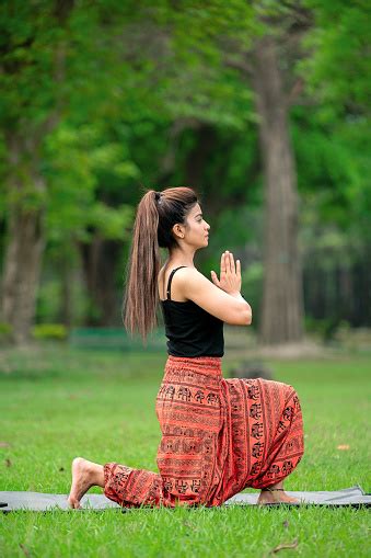 Wanita Muda Melakukan Yoga Asana Dengan Postur Namaste Sambil Duduk Di Tanah Di Taman Foto Stok