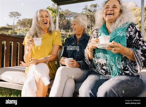 Les femmes âgées rient avec joie tout en prenant le thé ensemble