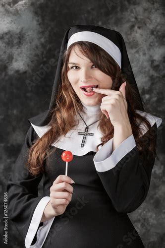 Young Sexy Stockings Nun Holding A Red Bonbon On A Dark Backgroundattractive Brunette Girl