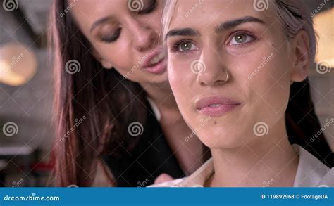 Young Beautiful Lesbian Whispering In One Ear Of Another Woman In Office During Working