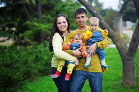 This full game walkthrough for twins of the pasture is currently in progress. Portrait of happy young parents with their two babies twins having fun in park | Stock Photo ...