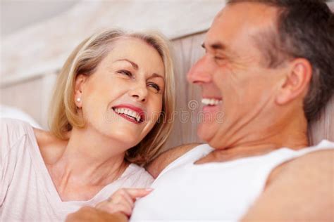 mature couple holding hands and looking at each other portrait of a cheerful mature couple