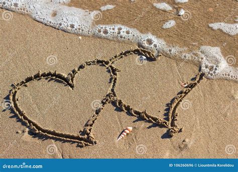 Two Hearts In The Sand On The Beach Waves With Foam Blue Sea O Stock