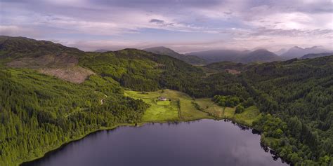 Aerial Photography Of Lake Surrounded With Land And Mountains Under