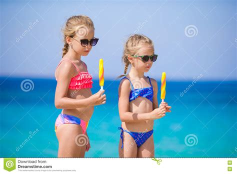 Ni As Felices Que Comen El Helado Durante Vacaciones De La Playa Gente Ni Os Amigos Y Concepto