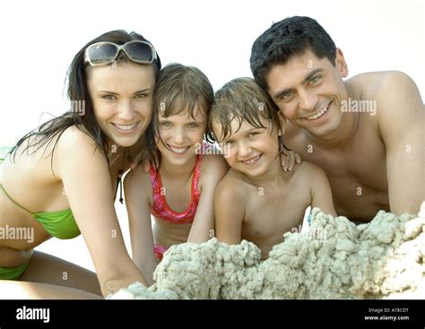 Familia Jugando En La Arena En La Playa Sonriendo A La Cámara Retrato Fotografía De Stock Alamy