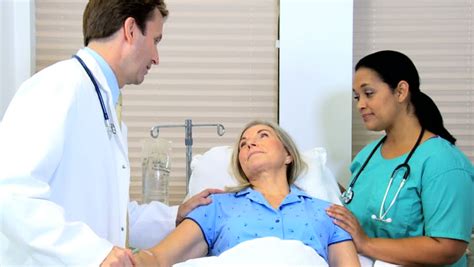 Hospital Doctor And Nurse Giving Medical Care To Mature Female Patient Stock Footage Video