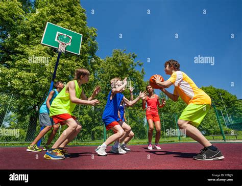 Teenage Children Playing Basketball Game Together Stock Photo Alamy