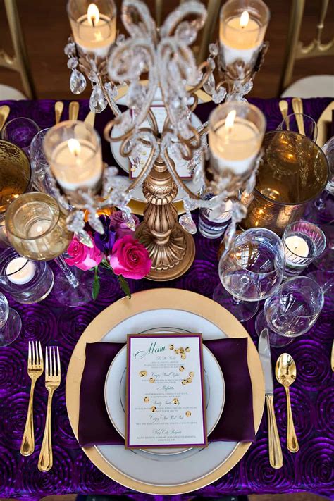 Lining the length of the table, silver dollar eucalyptus and gold tapered candles add simple, elegant color to this formal table setting. Separk Mansion wedding - table setting purple gold ...