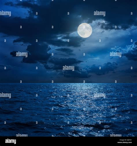 Full Moon In Clouds Over Sea In Night Stock Photo Alamy