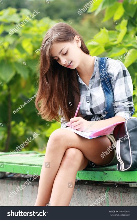 Beautiful School Or College Girl Sitting On The Bench With Book And Bag