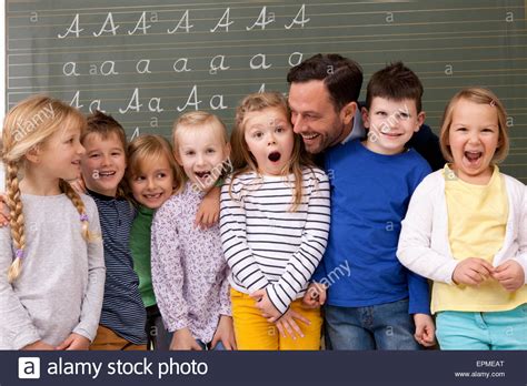 Happy Teacher With Pupils In Classroom Stock Photo Alamy